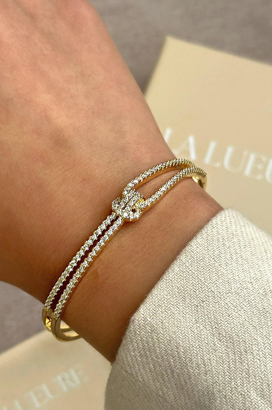 Gold knot bangle, elegant gold bracelet, sparkling bangle, high-quality stainless steel jewelry, luxurious bangle with stones, statement bracelet, stylish gold accessory, timeless jewelry design, La Lueure