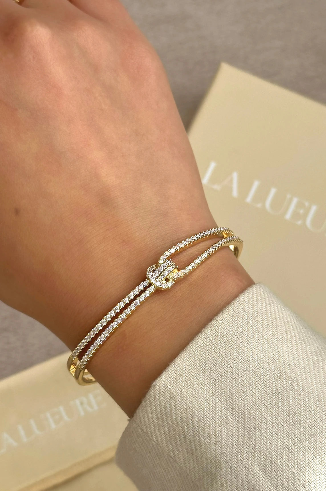 Gold knot bangle, elegant gold bracelet, sparkling bangle, high-quality stainless steel jewelry, luxurious bangle with stones, statement bracelet, stylish gold accessory, timeless jewelry design, La Lueure